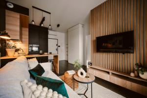 - un salon avec un canapé et une table dans l'établissement Przytulny Apartament Greenwall, à Cracovie