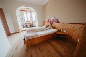 1 dormitorio con 1 cama grande y suelo de madera en Hotel - Restaurant Soleo, en Krumpendorf am Wörthersee