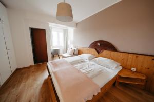 a bedroom with a large bed with a wooden headboard at Hotel - Restaurant Soleo in Krumpendorf am Wörthersee