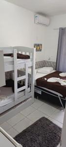 a room with two bunk beds and a bed at Pousada Casa Amarela Brisa Parque in Penha