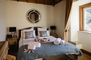 a bedroom with a bed with towels and a mirror at Suites at the Villas by Quinta da Bella Vista in Sintra