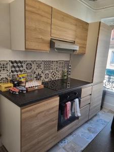 a kitchen with wooden cabinets and a stove top oven at Porte du Vieux Lyon 2, le long du quai in Lyon