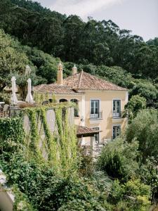 a house with ivy growing on the side of it at Suites at the Villas by Quinta da Bella Vista in Sintra