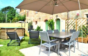 a table and chairs under an umbrella in a yard at Casa Mita con pacchetto mare incluso in Camaiore