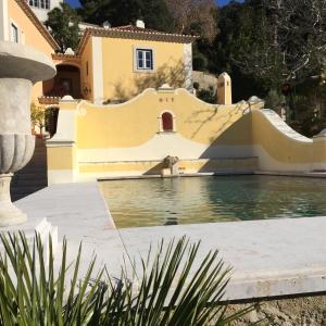 a house with a swimming pool in front of a house at Suites at the Villas by Quinta da Bella Vista in Sintra