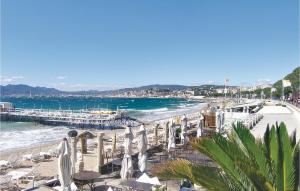 カンヌにあるBeautiful Apartment In Cannes With 1 Bedrooms And Wifiのビーチ(椅子、パラソル付)と桟橋