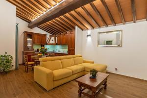 ein Wohnzimmer mit einem gelben Sofa und einem Tisch in der Unterkunft Gattaia Apartments with swimming pool in Gattaia
