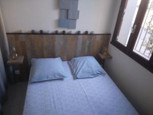 a bedroom with a bed with a wooden headboard and two pillows at plage du Môle in Cap d'Agde