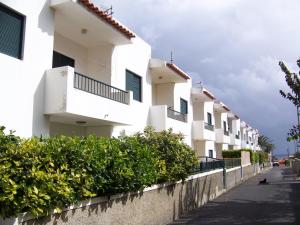 Une rangée d'immeubles d'appartements blancs dans une rue dans l'établissement Porto Santo Apartment, à Porto Santo