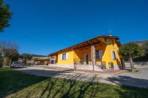 ein gelbes Haus mit einem davor geparkt in der Unterkunft Agriturismo Caperroni in Pescopagano