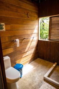 a bathroom with a toilet and a window at Cabaña La Kirita EcoHotel in Bahía Solano