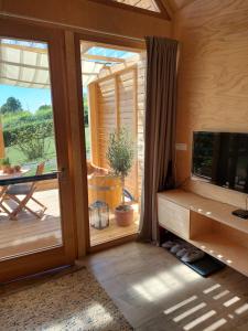 a room with a sliding glass door and a television at Hišice Čarna - Houses Čarna in Puconci