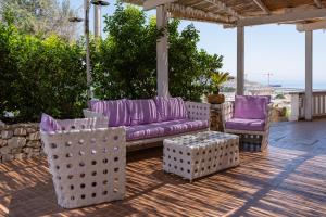 eine lila Couch und zwei Stühle auf einer Terrasse in der Unterkunft Il Pappagallo in Santa Maria di Leuca