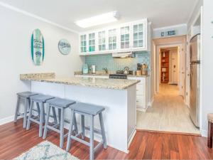 a kitchen with a counter and four stools at Beach Racquet A127 in Tybee Island