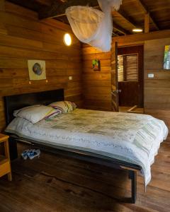 a bedroom with a bed in a wooden cabin at playa mecana kirita in Bahía Solano