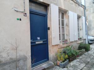 eine blaue Tür an der Seite eines Gebäudes in der Unterkunft vieux-Cognac, chambre avec sa salle de bain privative in Cognac