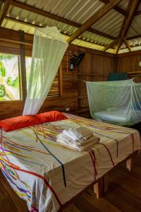 Un dormitorio con una cama con una red. en playa mecana kirita, en Bahía Solano