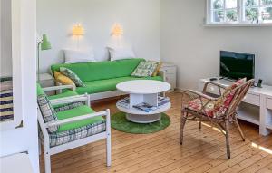 uma sala de estar com um sofá verde e cadeiras em Stunning Home In Skummeslvsstrand With Kitchen em Skummeslövsstrand