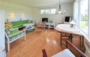 uma sala de estar com um sofá verde e uma mesa em Stunning Home In Skummeslvsstrand With Kitchen em Skummeslövsstrand
