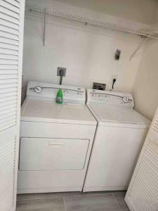 una piccola lavanderia bianca con due lavatrici e una lavatrice di Naples Paradise a Naples