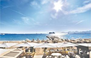 カンヌにある1 Bedroom Amazing Apartment In Cannesの白い傘と海のビーチ
