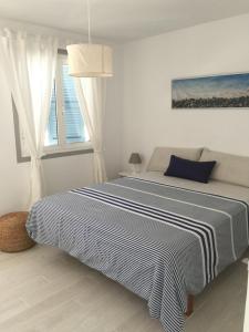 a bedroom with a bed with a blue and white blanket at Casa Acapulco in Mahón