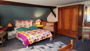 a bedroom with a bed and a wooden cabinet at Gîte Le Jardin in Geispolsheim