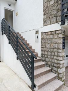 um conjunto de escadas com um corrimão preto ao lado de um edifício em Apartments Klenovica Jadranka Čačić em Klenovica