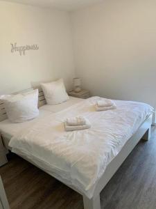 uma cama branca com duas toalhas em cima em 47 2 N Waterkant em Wangerland