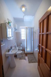 ein Badezimmer mit 2 WCs, einem Waschbecken und einer Dusche in der Unterkunft Agriturismo Caperroni in Pescopagano