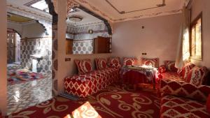 a living room with red chairs and a table at Dar Arghen Family Lodge in Imlil