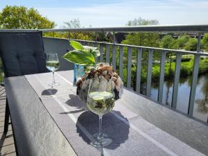 uma mesa com dois copos de vinho e um ananás em 47 3 M Seestern em Wangerland