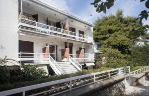 a white house with white stairs and a balcony at Vouliagmeni Art Micro Loft in Athens