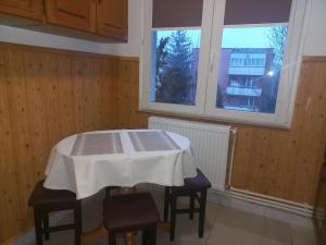 a table in a room with a table and two windows at City Center Flat in Odorheiu Secuiesc