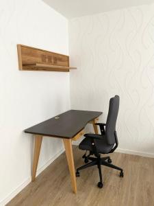einen Schreibtisch und einen Stuhl in einem Zimmer mit einer Wand in der Unterkunft Sehr zentral, geräumiges, helles Studio-Apartment in Köln