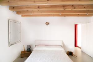 Schlafzimmer mit einem weißen Bett und Holzdecken in der Unterkunft Giardino in laguna in Murano