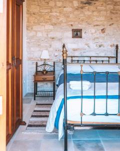 a bedroom with a bed and a table with a lamp at Lazaros Stonehouse in Pano Lefkara