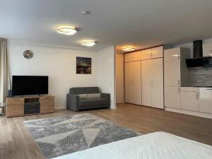 sala de estar con sofá y TV y cocina en Sehr zentral, geräumiges, helles Studio-Apartment en Colonia