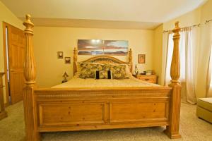 a bed with a wooden frame in a bedroom at Beautiful home 10 min E of Boulder in Lafayette