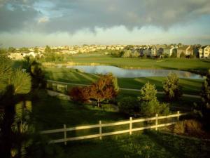 a view of a golf course with a fence and a lake at Beautiful home 10 min E of Boulder in Lafayette