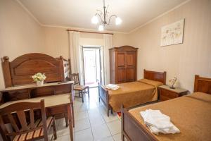 a hotel room with two beds and a desk at Agriturismo Caperroni in Pescopagano