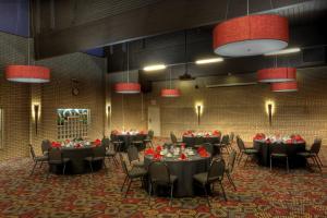 a banquet hall with tables and chairs with red flowers on them at Royal Hotel Lloydminster in Lloydminster