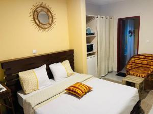 a bedroom with two beds and a mirror on the wall at Résidence Karamel Yaoundé Anguissa in Yaoundé