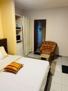 a bedroom with two beds and a room with a kitchen at Résidence Karamel Yaoundé Anguissa in Yaoundé