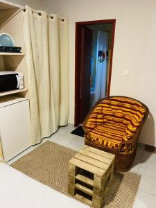 a room with a ottoman and a stool in a kitchen at Résidence Karamel Yaoundé Anguissa in Yaoundé