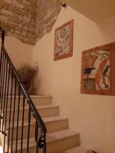 uma escada numa casa com duas fotografias na parede em Corte Landriani em Montefelcino