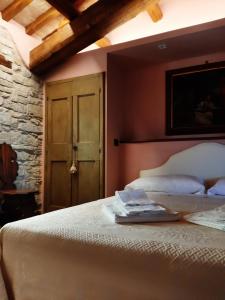 um quarto com uma cama branca e um tecto de madeira em Corte Landriani em Montefelcino