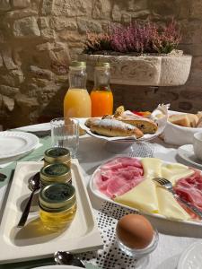 uma mesa coberta com pratos de comida e sumo de laranja em Corte Landriani em Montefelcino