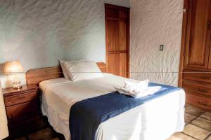 1 dormitorio con 1 cama con manta azul y blanca en Mi caleta en Galápagos, en Puerto Ayora
