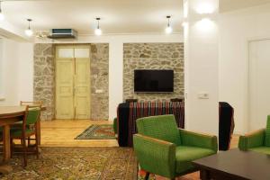 ein Wohnzimmer mit einem Tisch, Stühlen und einem TV in der Unterkunft Your villa with garden in Martuni next to Sevan lake in Martuni
